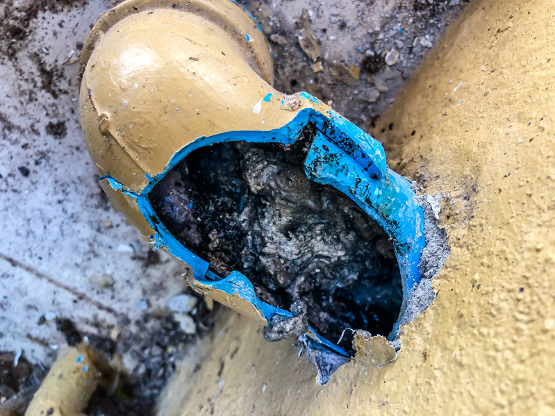 Close-up image of clogged pipe, cracked open.